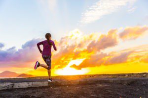 A person running on the beach at sunset