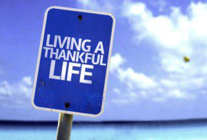 A blue sign that says living a thankful life.